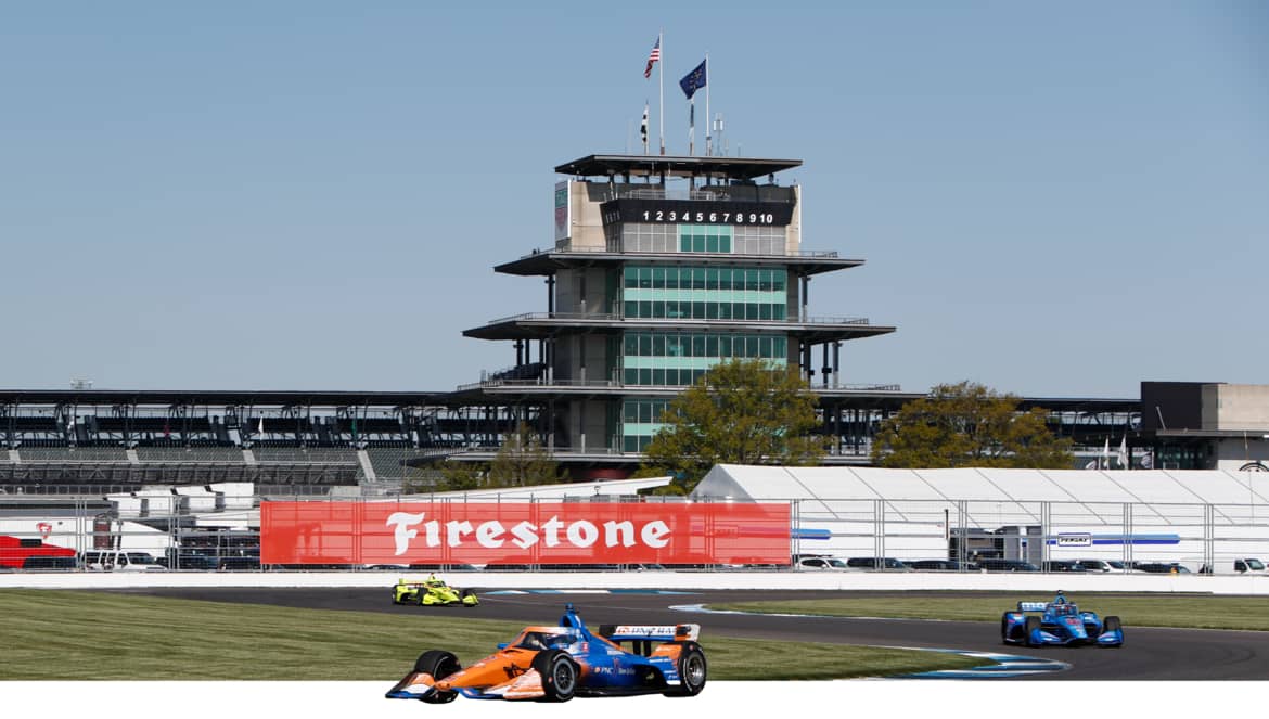 Formula race car on track, under Firestone banner