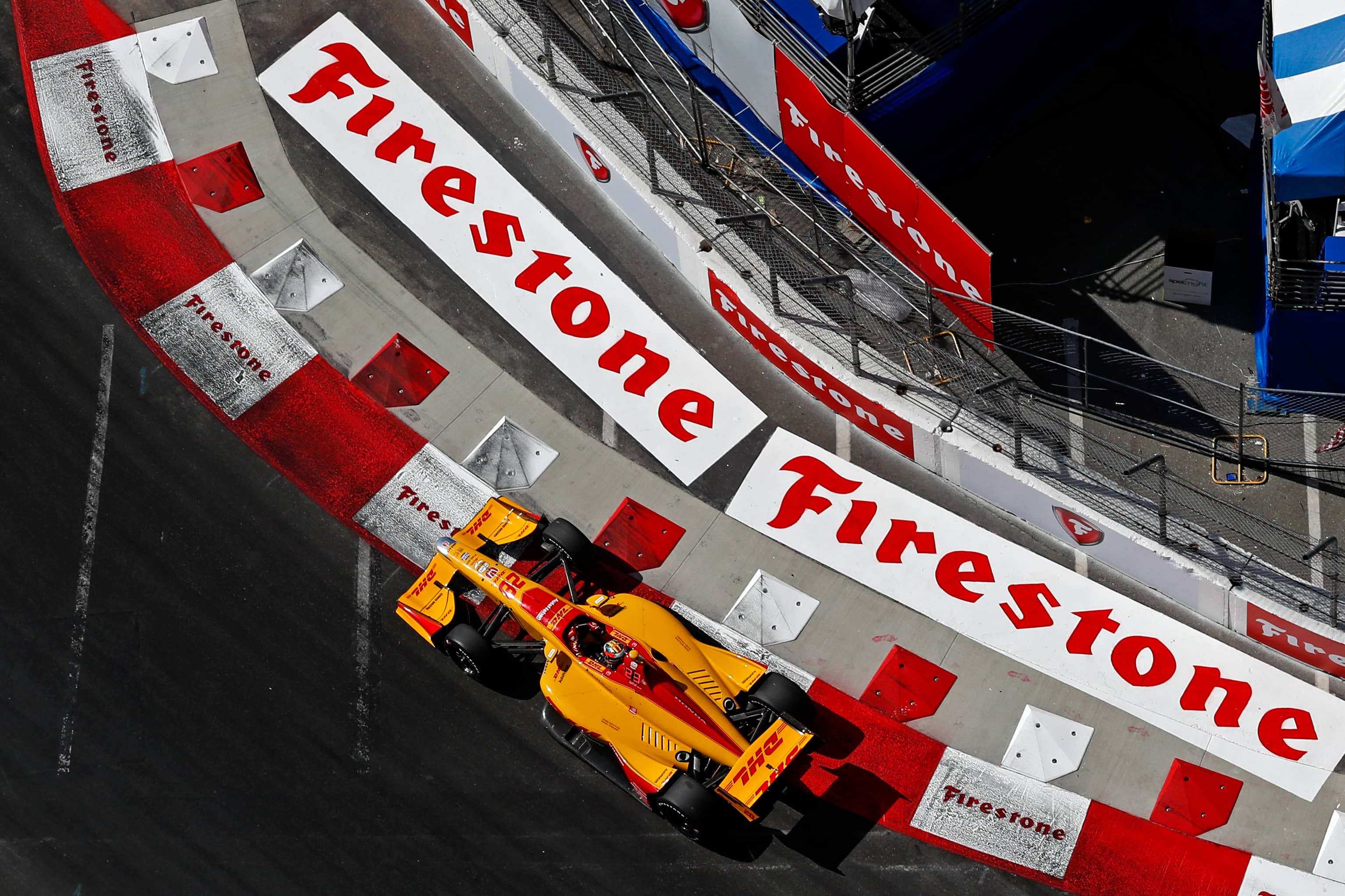 Top view of Formula car on racetrack with Firestone logos.