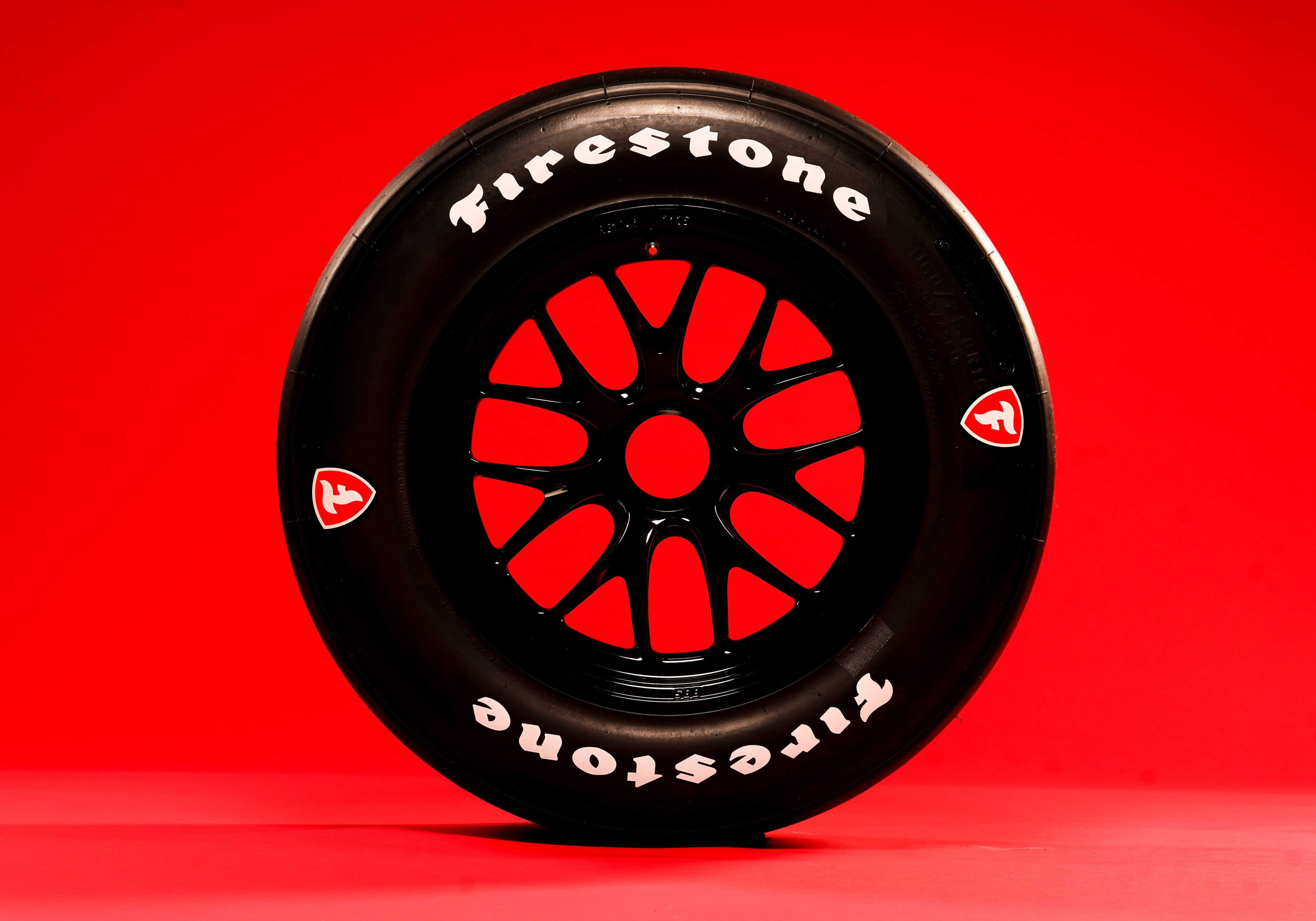 Side view of Firestone race tire, red background