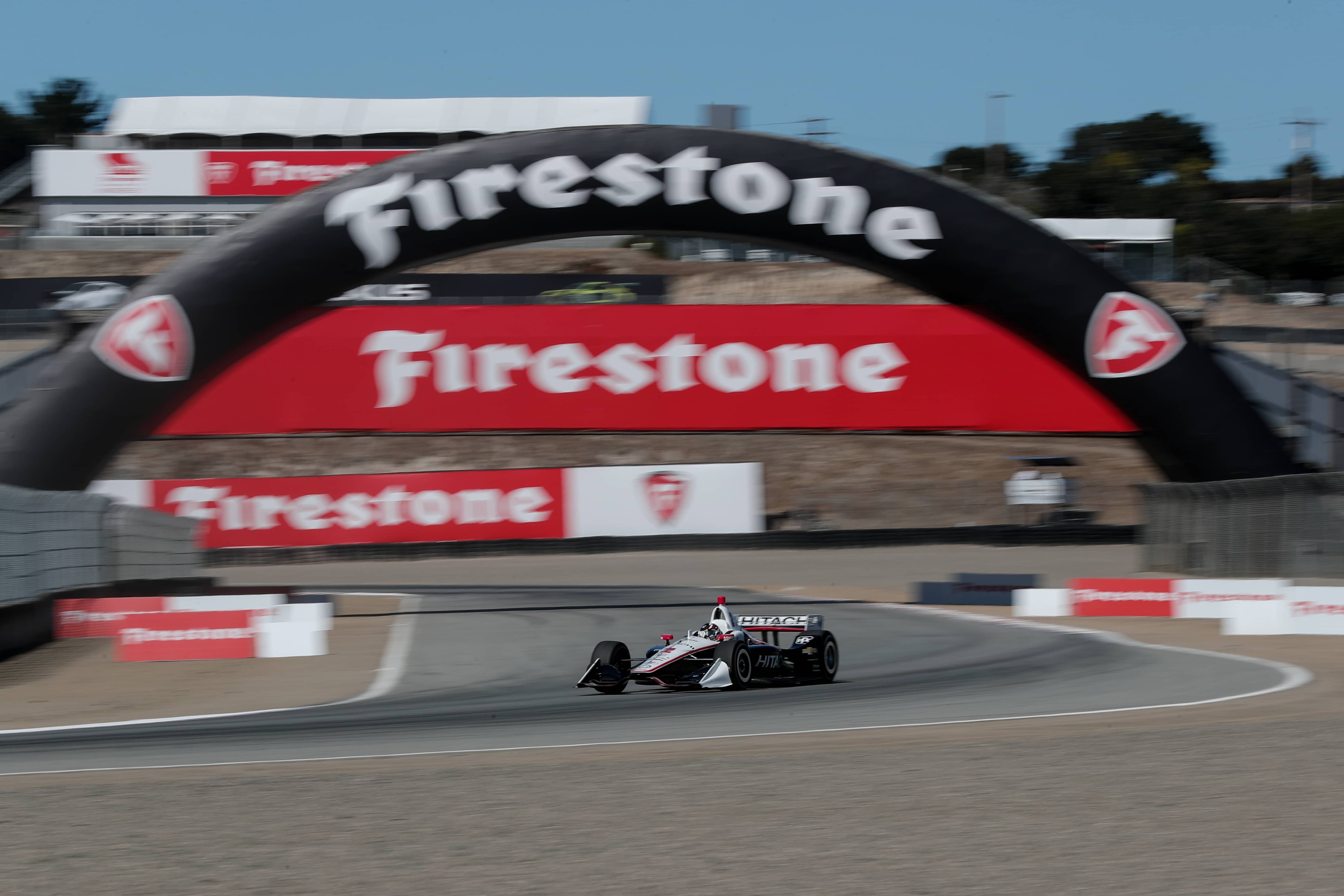 Formula race car on track, under Firestone banner